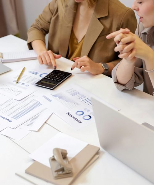 Two professionals collaborating on financial documents in a modern office setting.